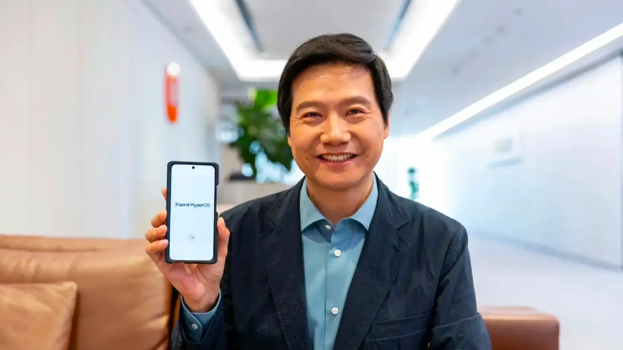 Lei Jun, CEO of Xiaomi, showcasing a Xiaomi smartphone equipped with HyperOS