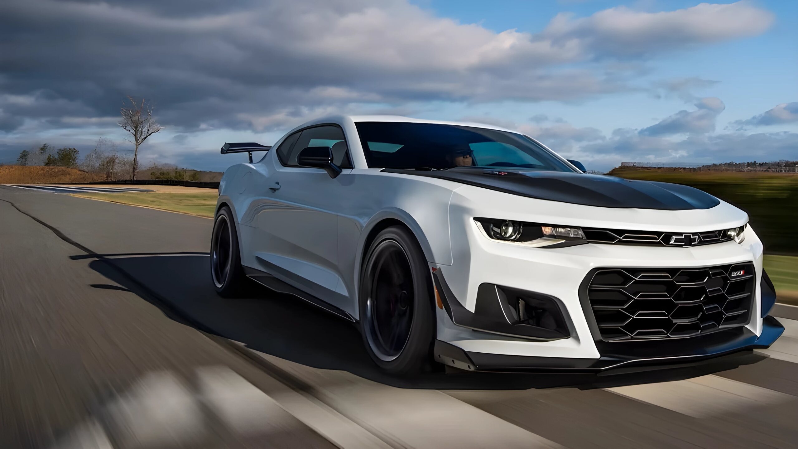 A The Front And Side Profiles Of The 2024 Chevrolet Camaro - Exterior Shade Summit White With A Visible Carbon Fiber Weave Hood Insert