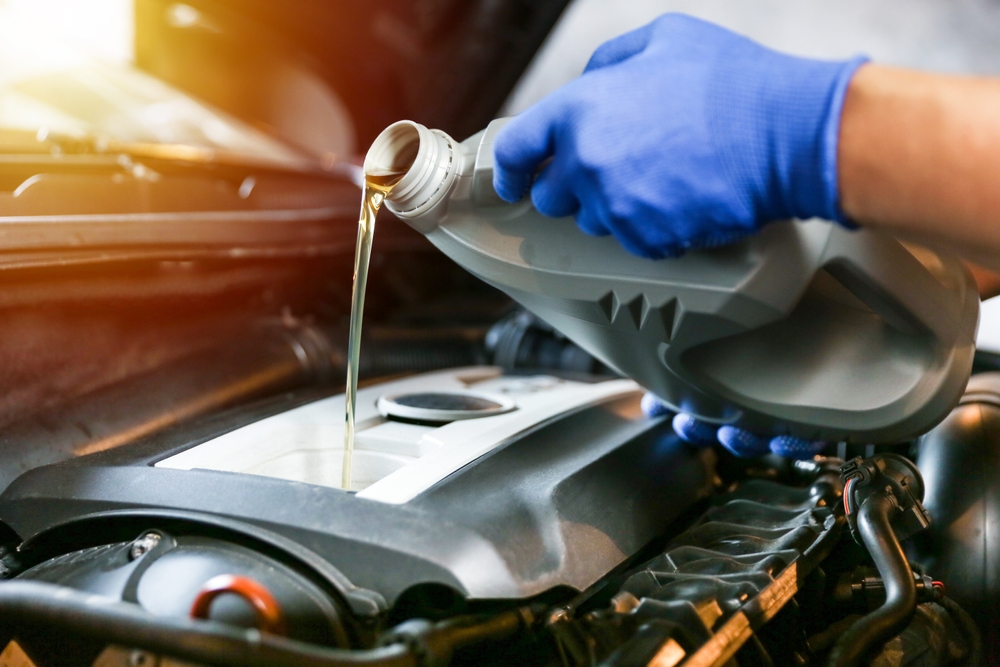 Car,Oil,Is,Pouring,Into,The,Engine,Close,Up.,Pouring