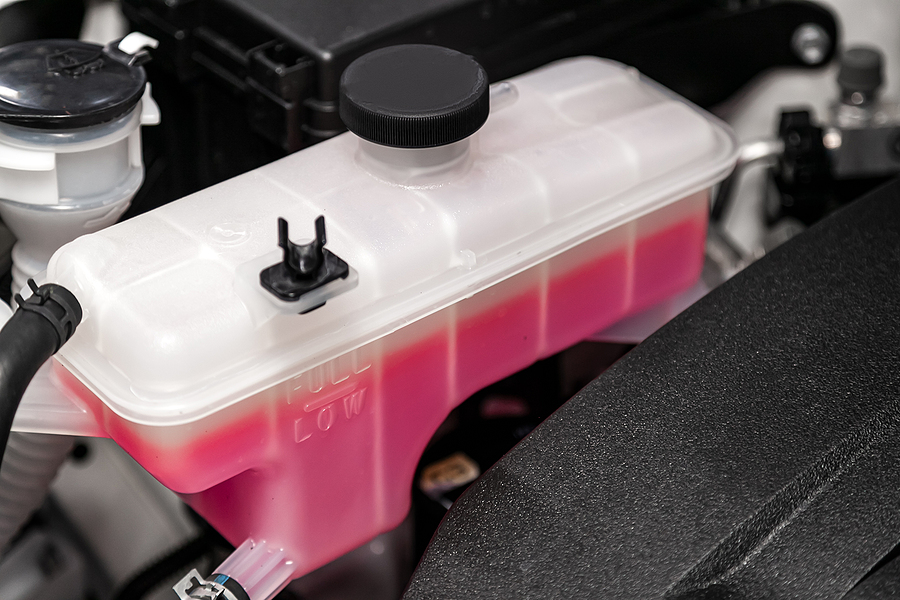 Close up White Expansion Tank With Pink Antifreeze. Car Coolant