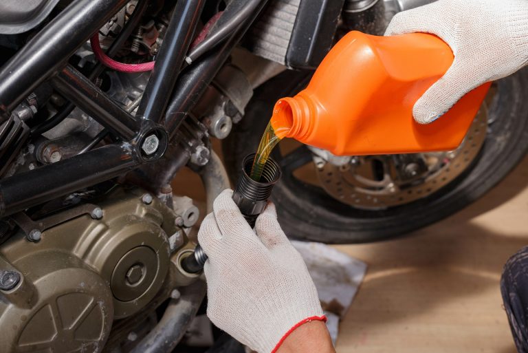 The process of pouring new oil into the motorcycle engine.