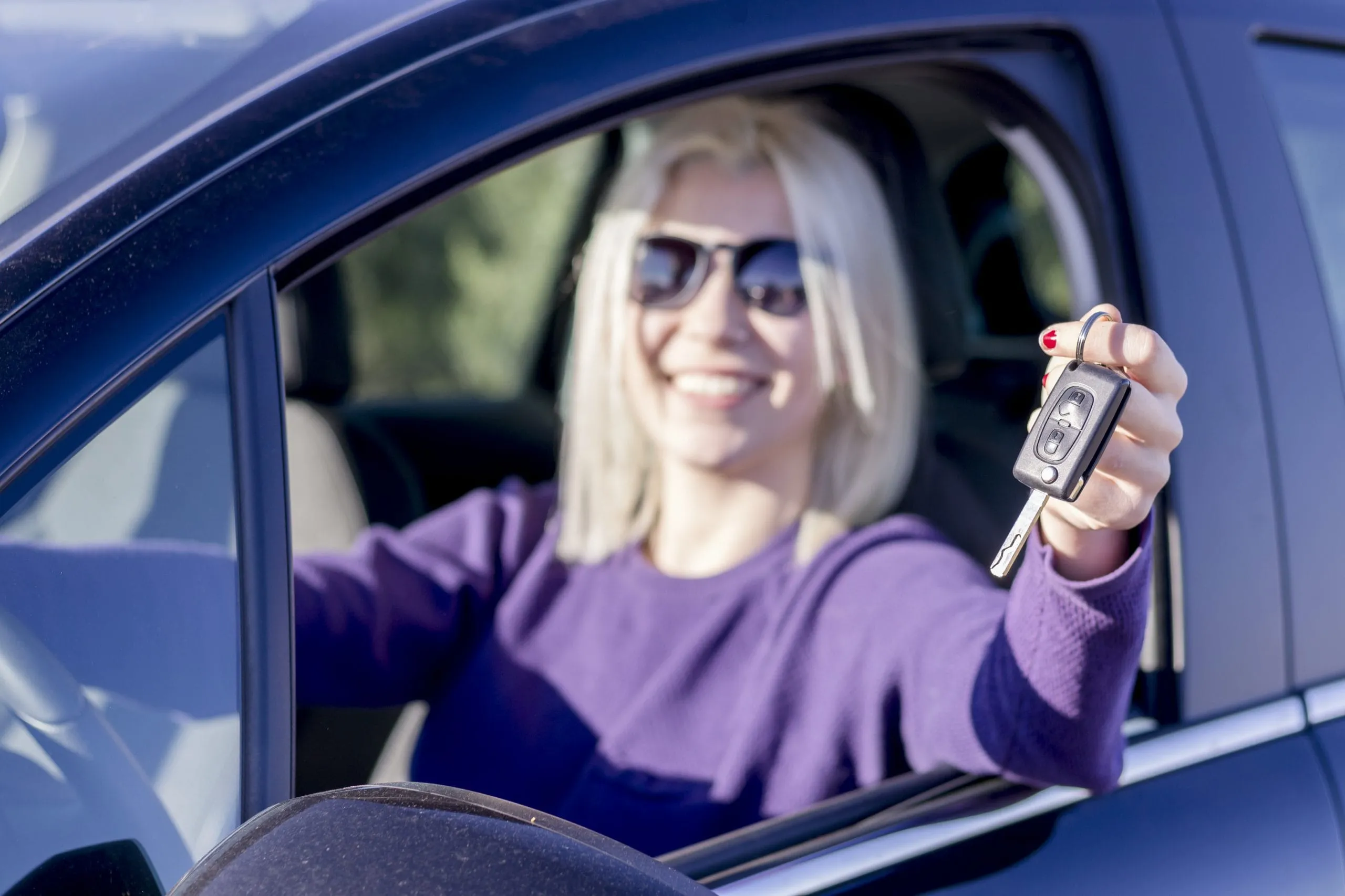 Lady in a car wearing sunglasses