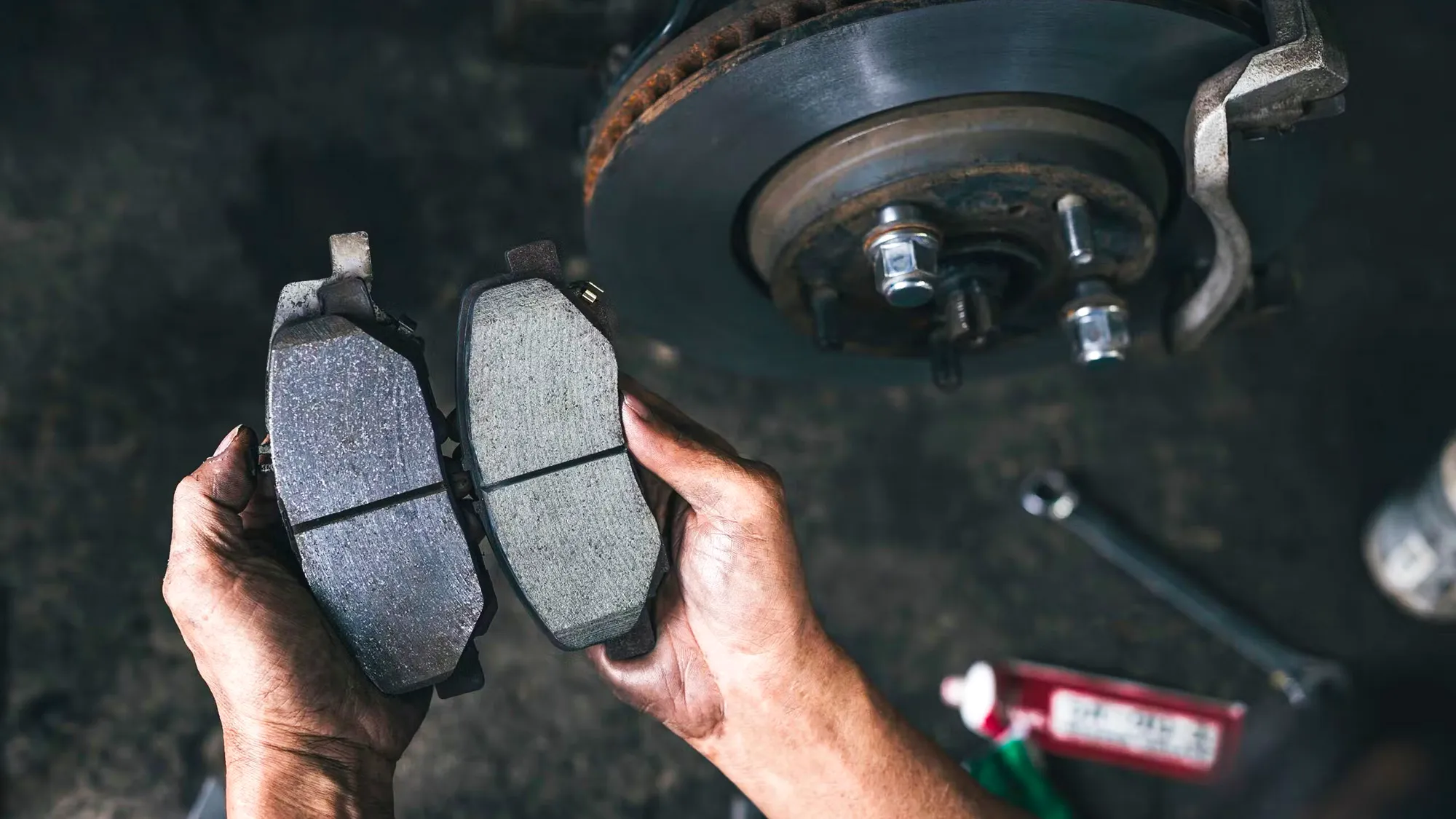 Set of car brake pads being held by a mechanic Set of car brake pads being held by a mechanic