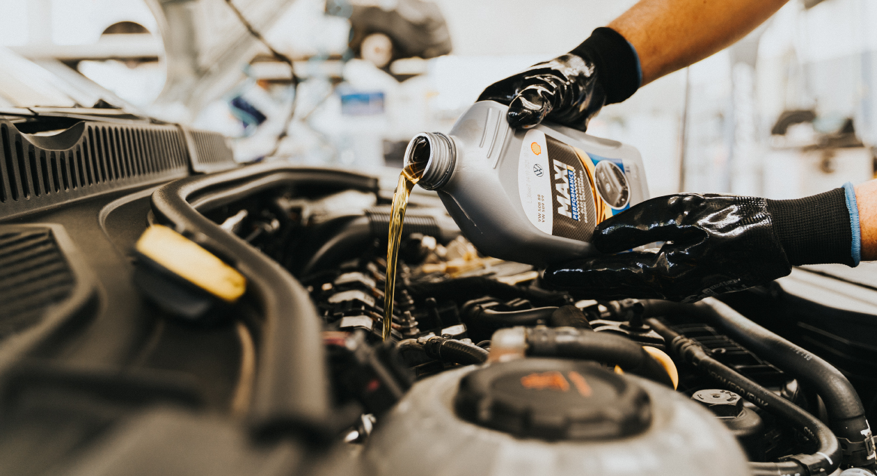 Pouring synthetic engine oil into a car engine