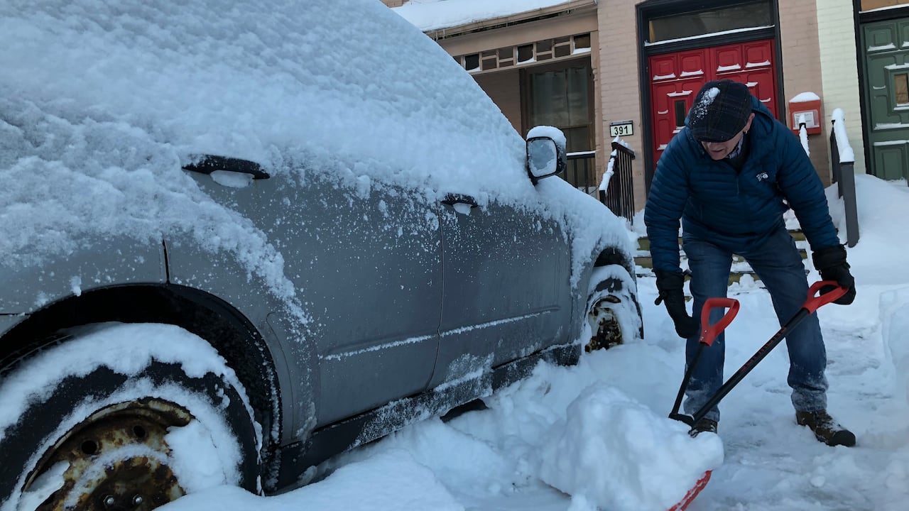 Shoveling snow away from a vehicle