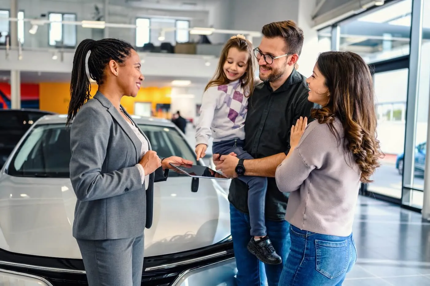 A family interacting with a salesperson in a car dealership