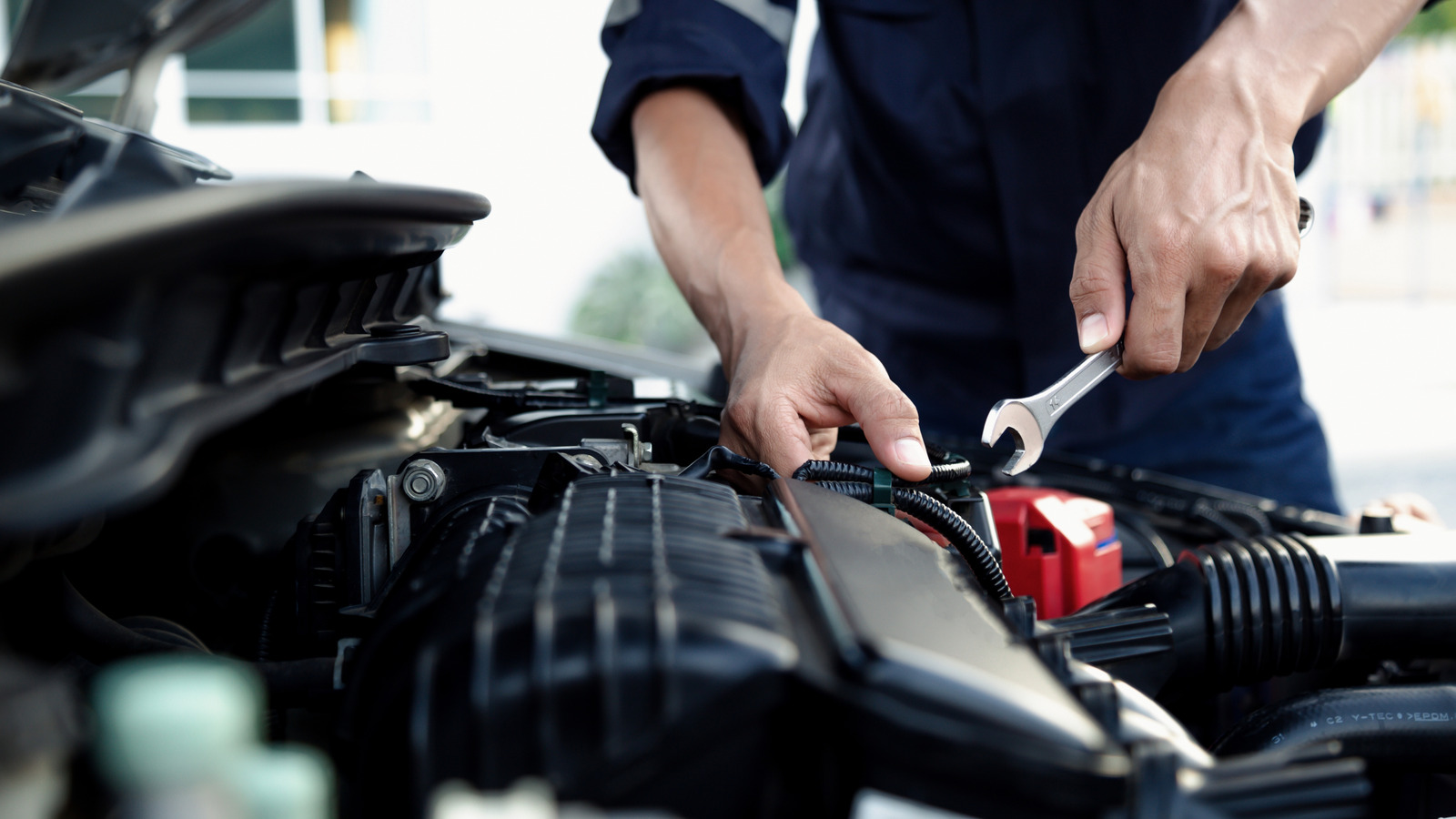 Mechanic performing maintenance on a vehicle's engine