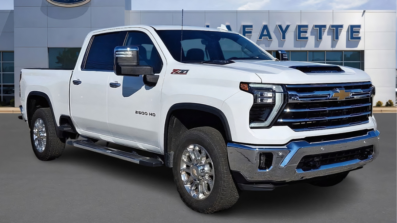 A clean white Chevrolet Silverado heavy-duty pickup truck parked in front of a dealership