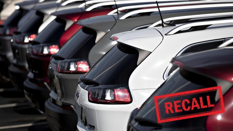 A row of parked SUVs with a red 'RECALL' stamp in the foreground