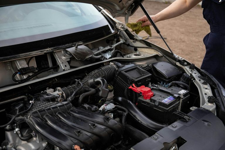 Car battery inspection under open hood