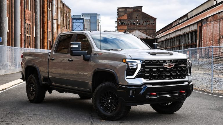 grey Chevrolet pickup truck parked on an industrial street with old brick buildings