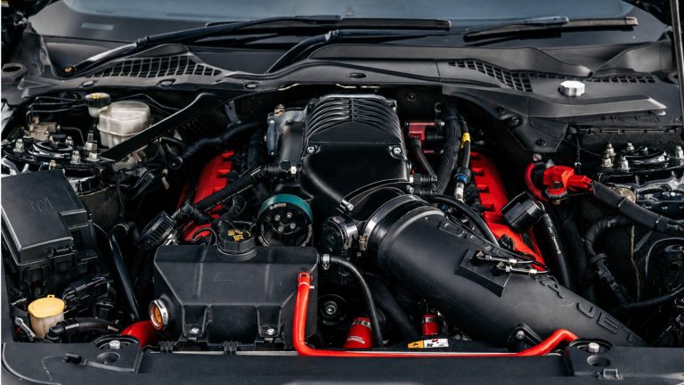 Close-up of a supercharged American V8 engine with exposed intake and blower