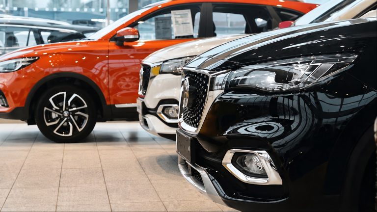 close-up view of black, white, and orange cars parked inside a showroom