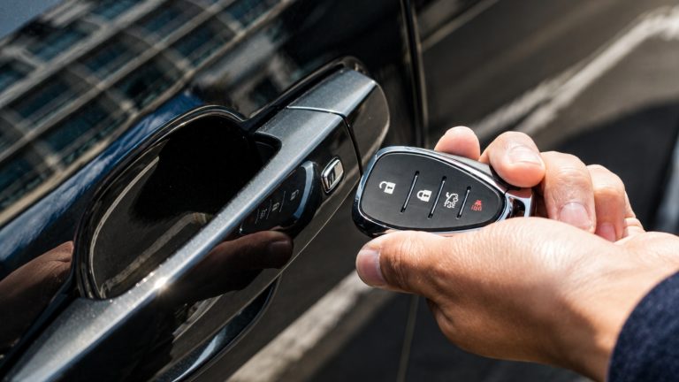 Close-up of a luxury car door handle with smart key nearby.