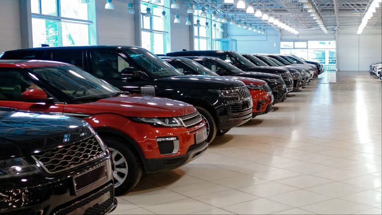 long row of luxury SUVs parked inside bright showroom
