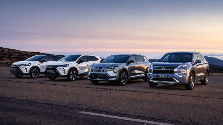 Four modern Mitsubishi SUVs parked in a row on a scenic road at sunset