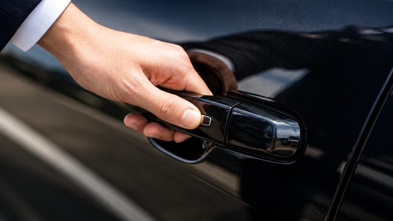 Close-up of a luxury vehicle door handle with smart key fob nearby.