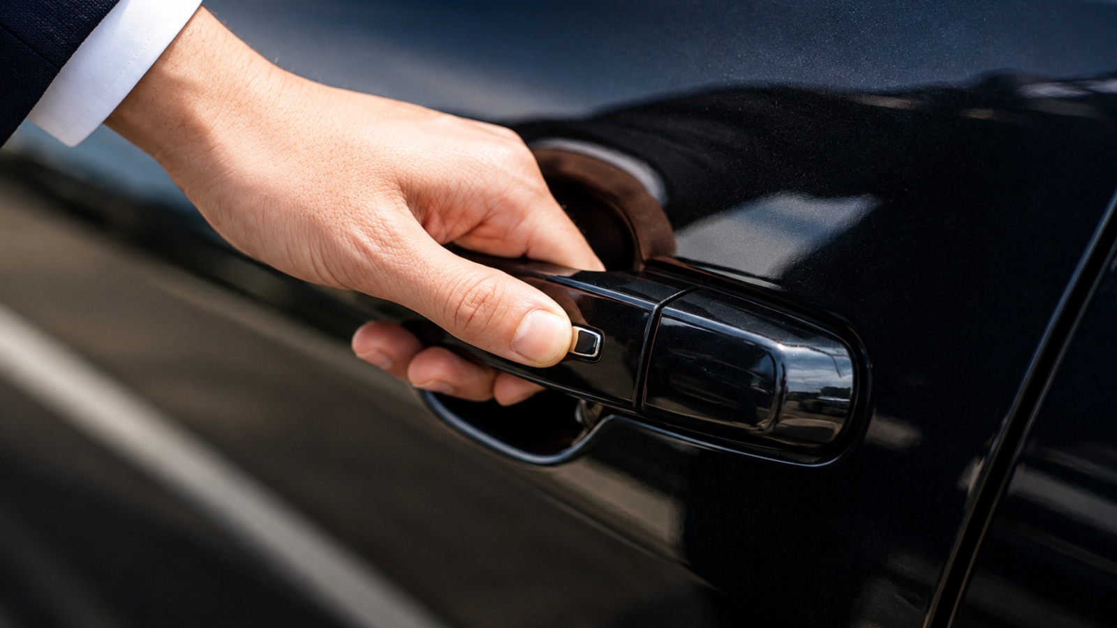 Close-up of a luxury vehicle door handle with smart key fob nearby.