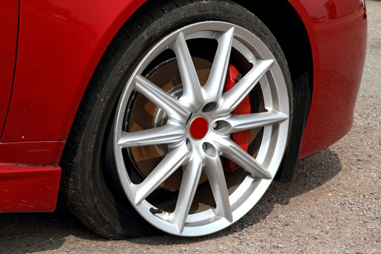 A broken tire in a red car is shown