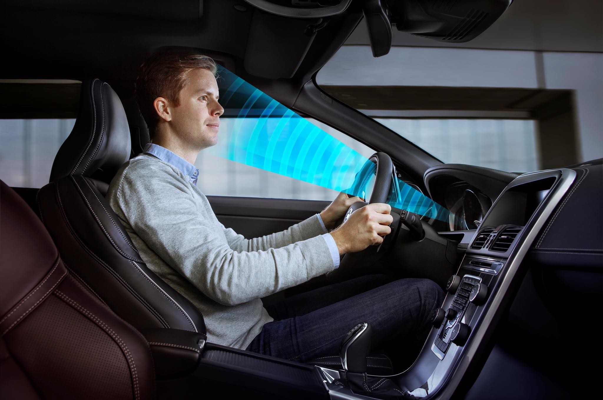 A driver sitting inside a car with a blue graphical scanner monitoring his face