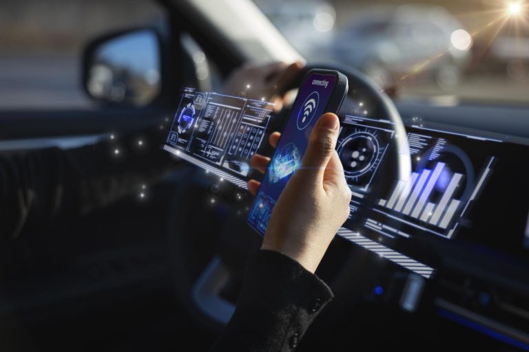 A person inside a car holding a smartphone surrounded by glowing digital interface graphics