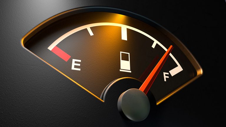 A close-up view of a car fuel gauge pointing to full