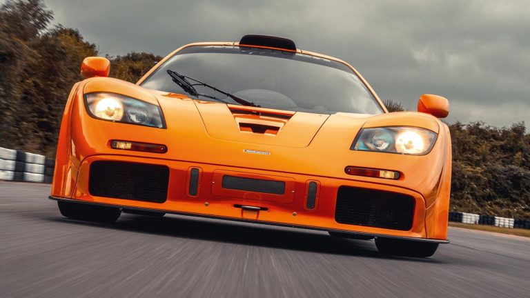 McLaren F1 supercar parked in dramatic lighting from a low front angle