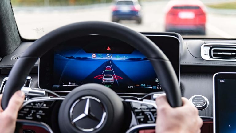 A driver's view from inside a Mercedes showing a digital dashboard and advanced driver assistance systems