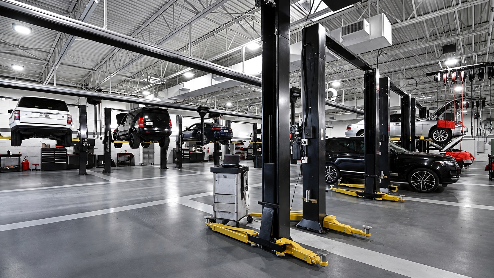 bright modern auto repair shop with multiple cars elevated on hydraulic lifts