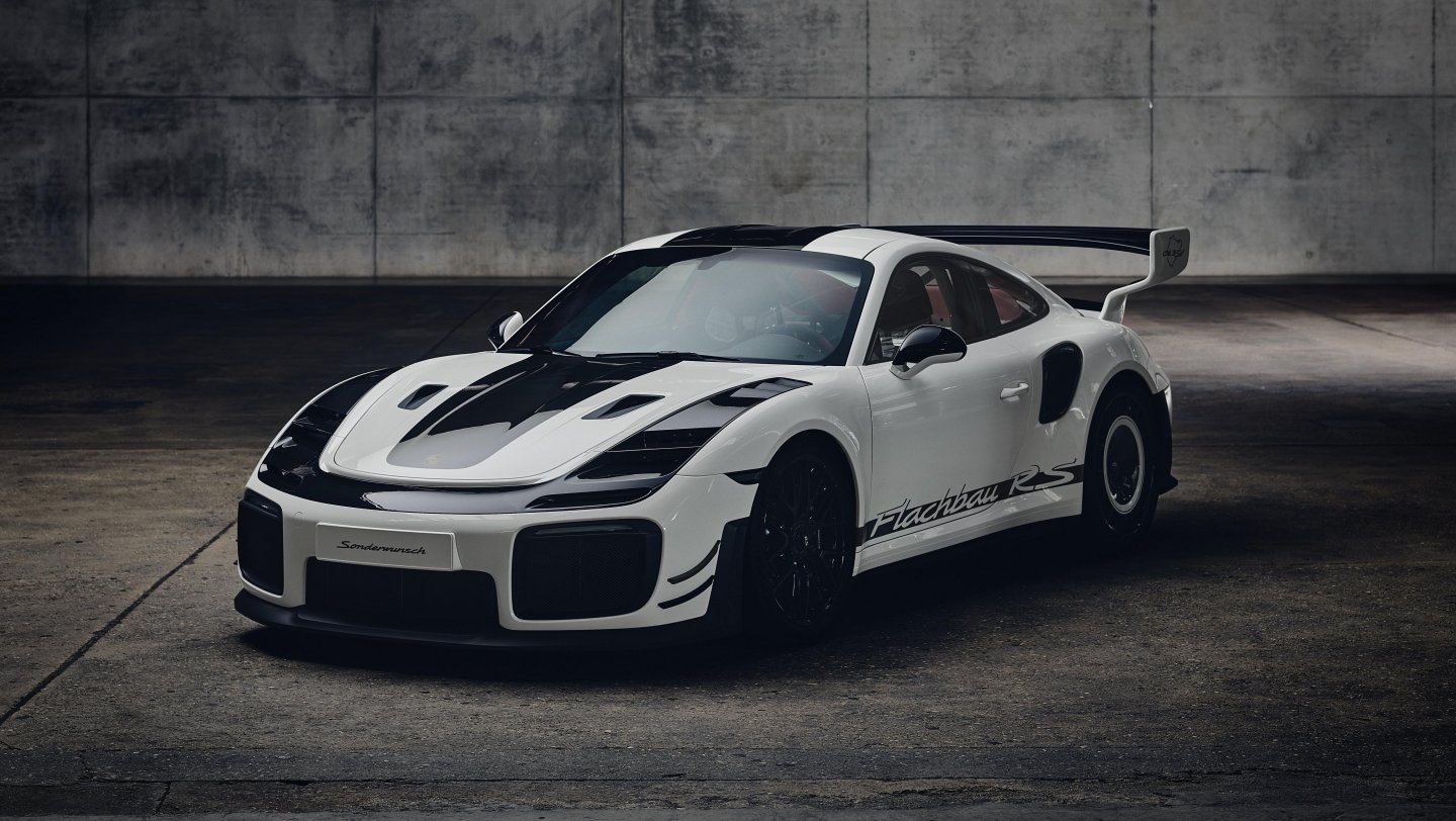 white and black Porsche 911 GT2 Flachbau RS parked indoors against a concrete wall