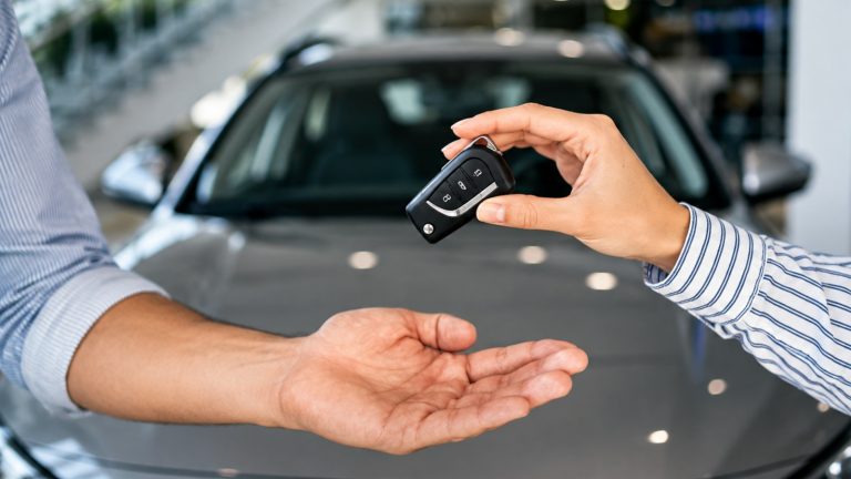A car key is being given to another person