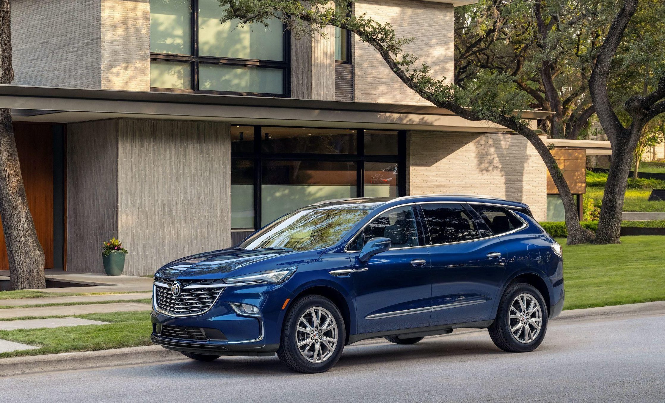 Modern Buick SUV parked in a suburban driveway during golden hour