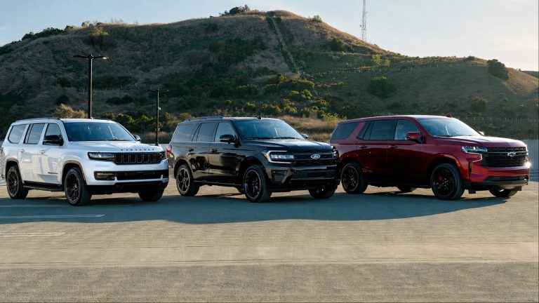 Chevrolet Tahoe, Ford Expedition, and Jeep Wagoneer parked against scenic hillside