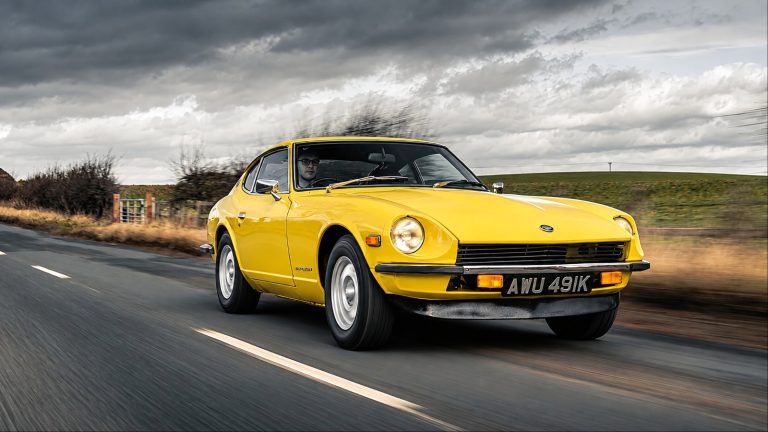 Bright yellow Datsun 240Z driving fast on a country road