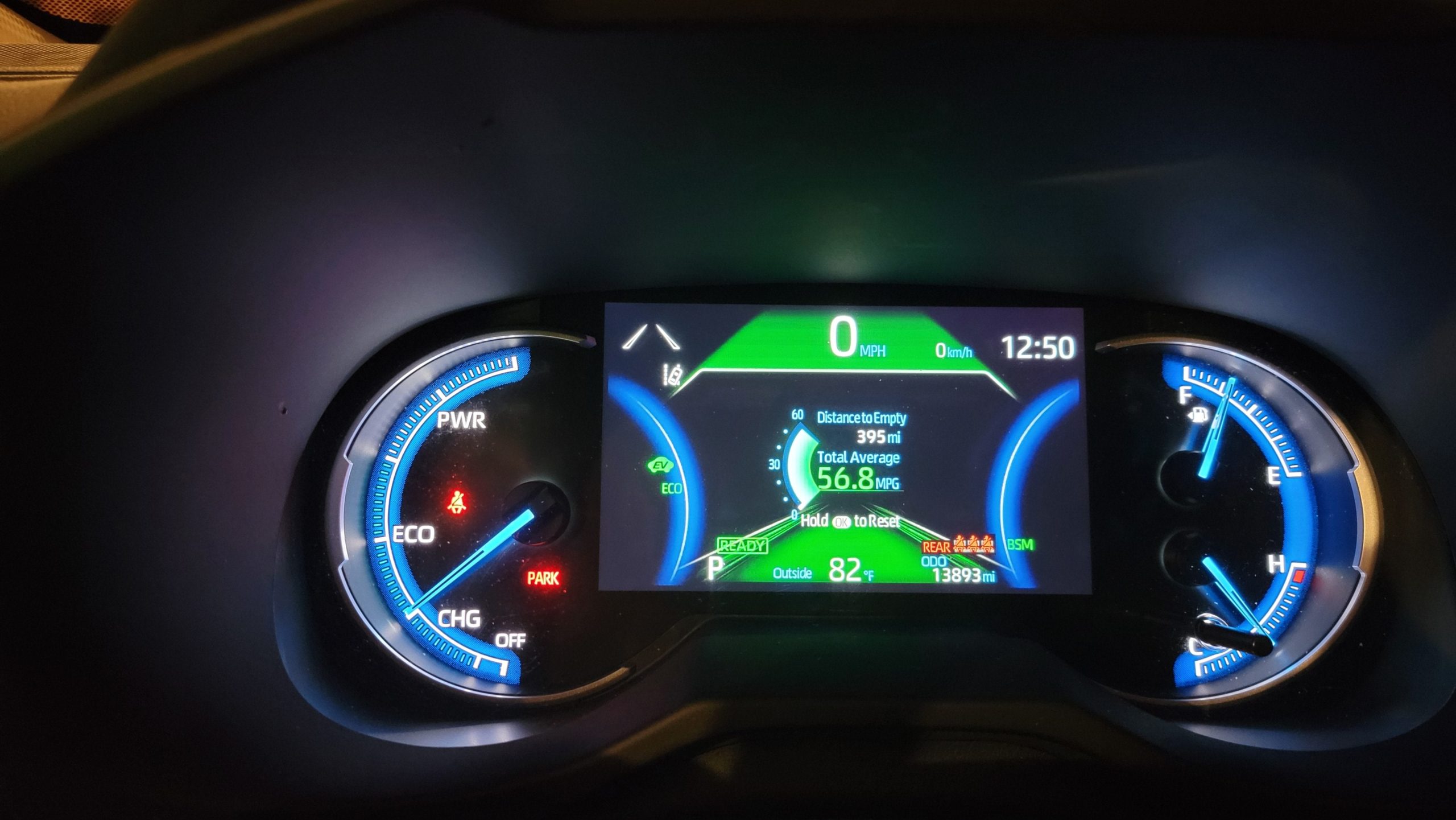 Digital instrument cluster of a Toyota RAV4 Hybrid displaying a total average fuel economy of 56.8 MPG and a distance to empty of 395 miles