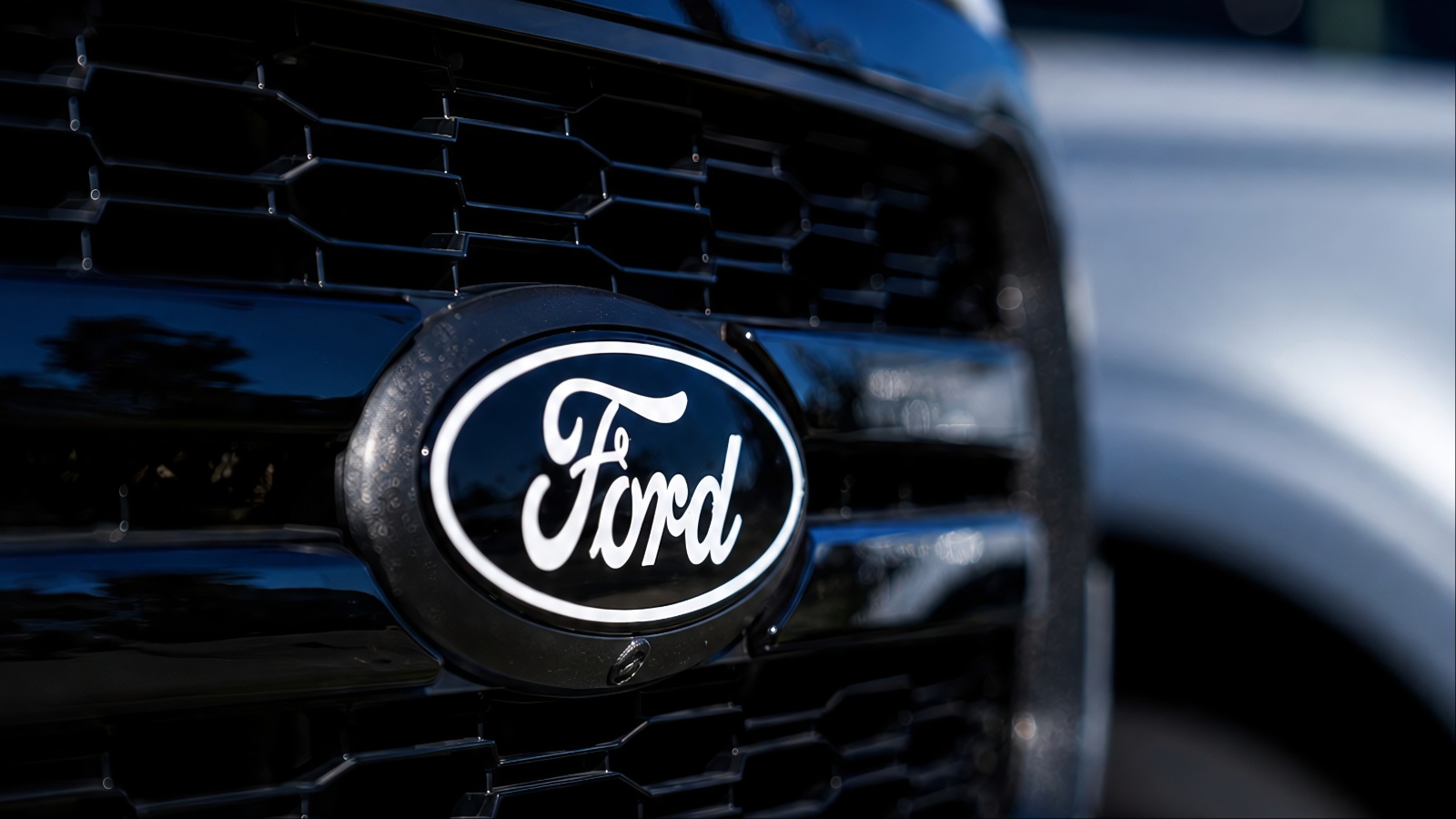 Close-up shot of a black Ford vehicle front grille logo