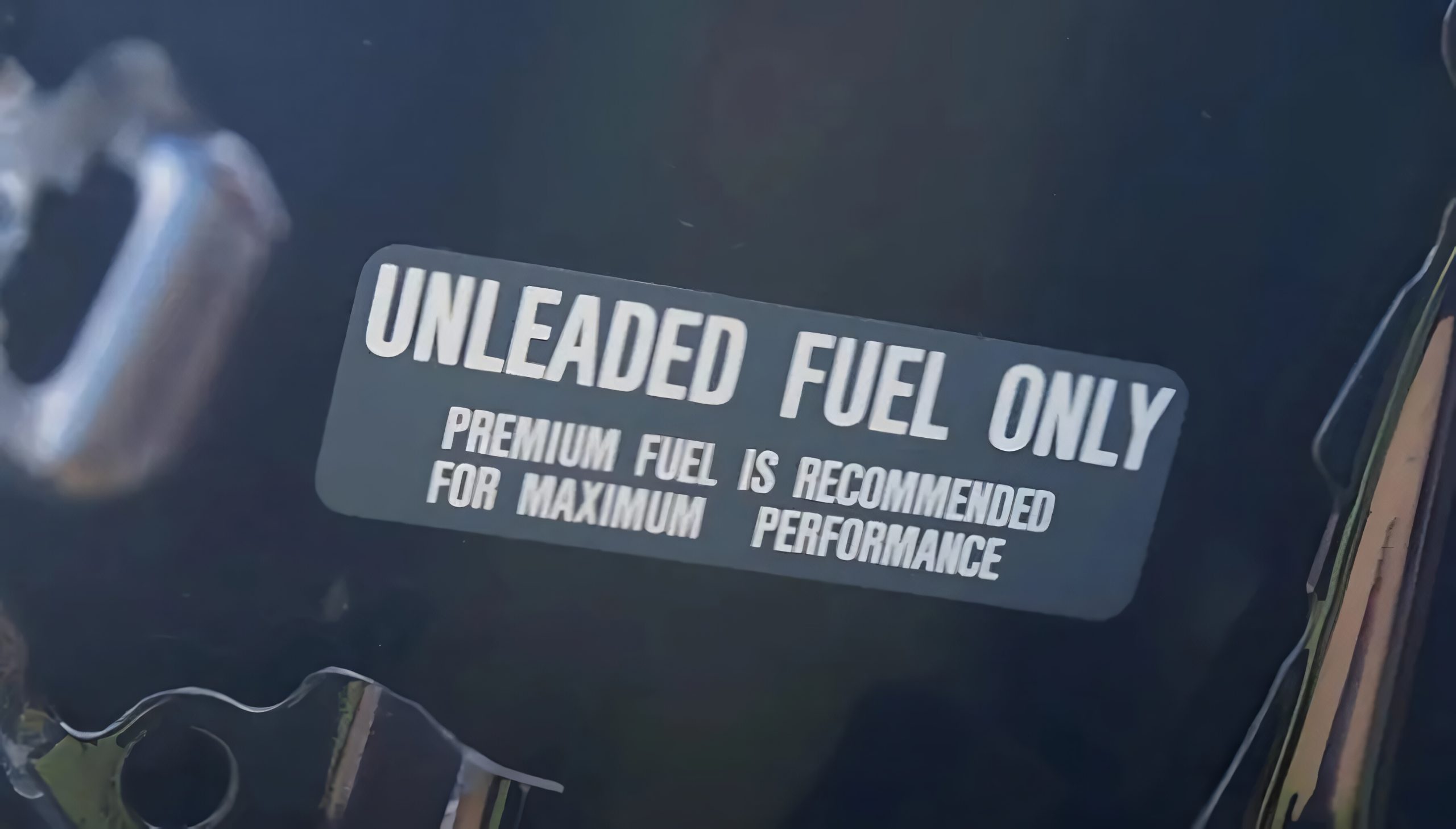 Fuel door sticker indicates that the vehicle requires unleaded gasoline