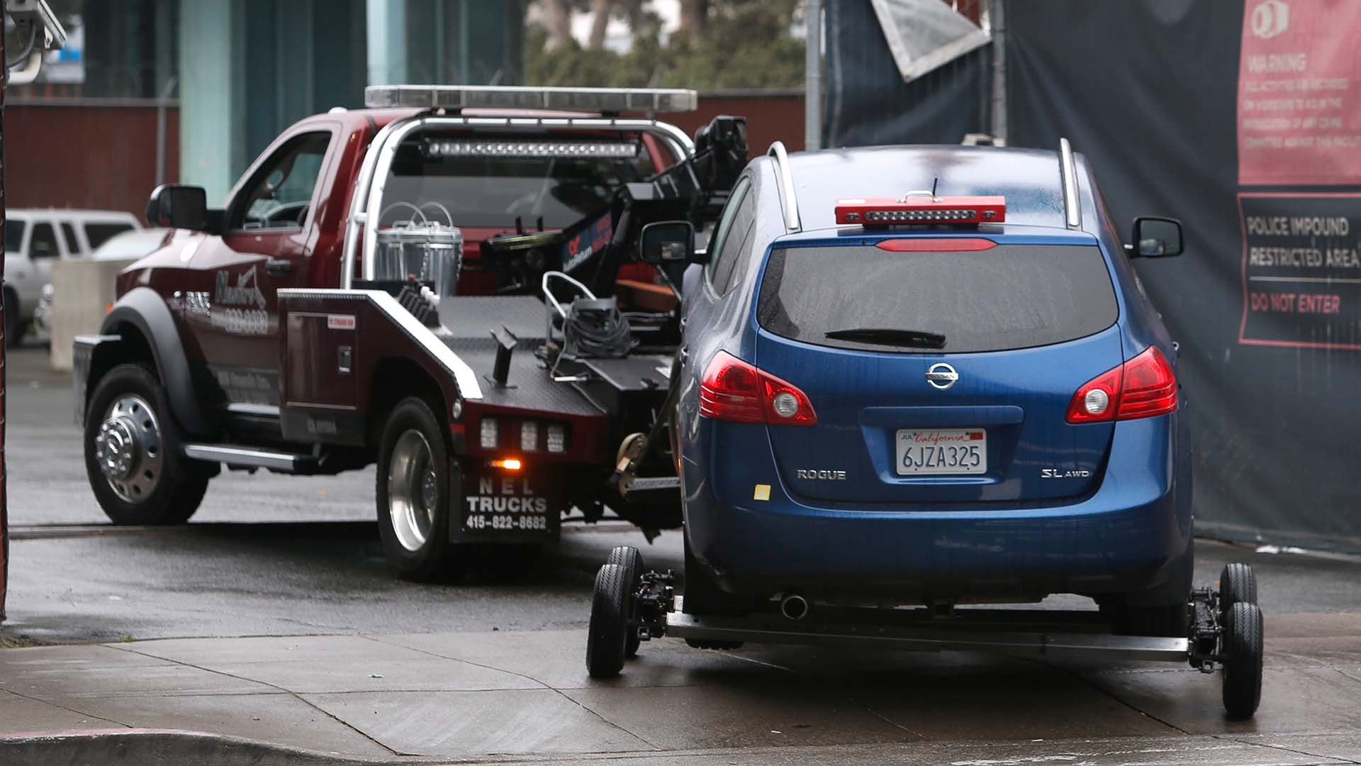 Heavy-duty tow truck from Nel Trucks transporting a blue Nissan Rogue