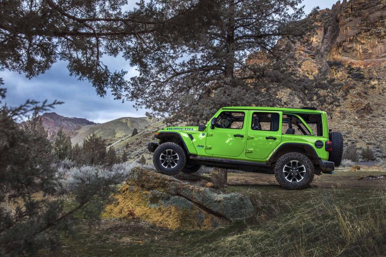 A Jeep Wrangler is standing on a rough hill
