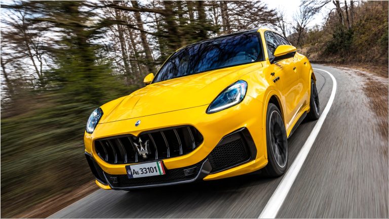 bright yellow Maserati SUV driving on a winding road