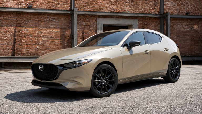 Mazda3 hatchback parked in front of a modern industrial backdrop