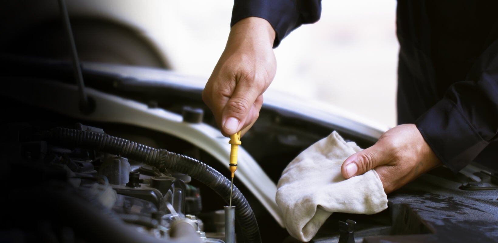 Mechanic is checking the engine oil level Mechanic is checking the engine oil level