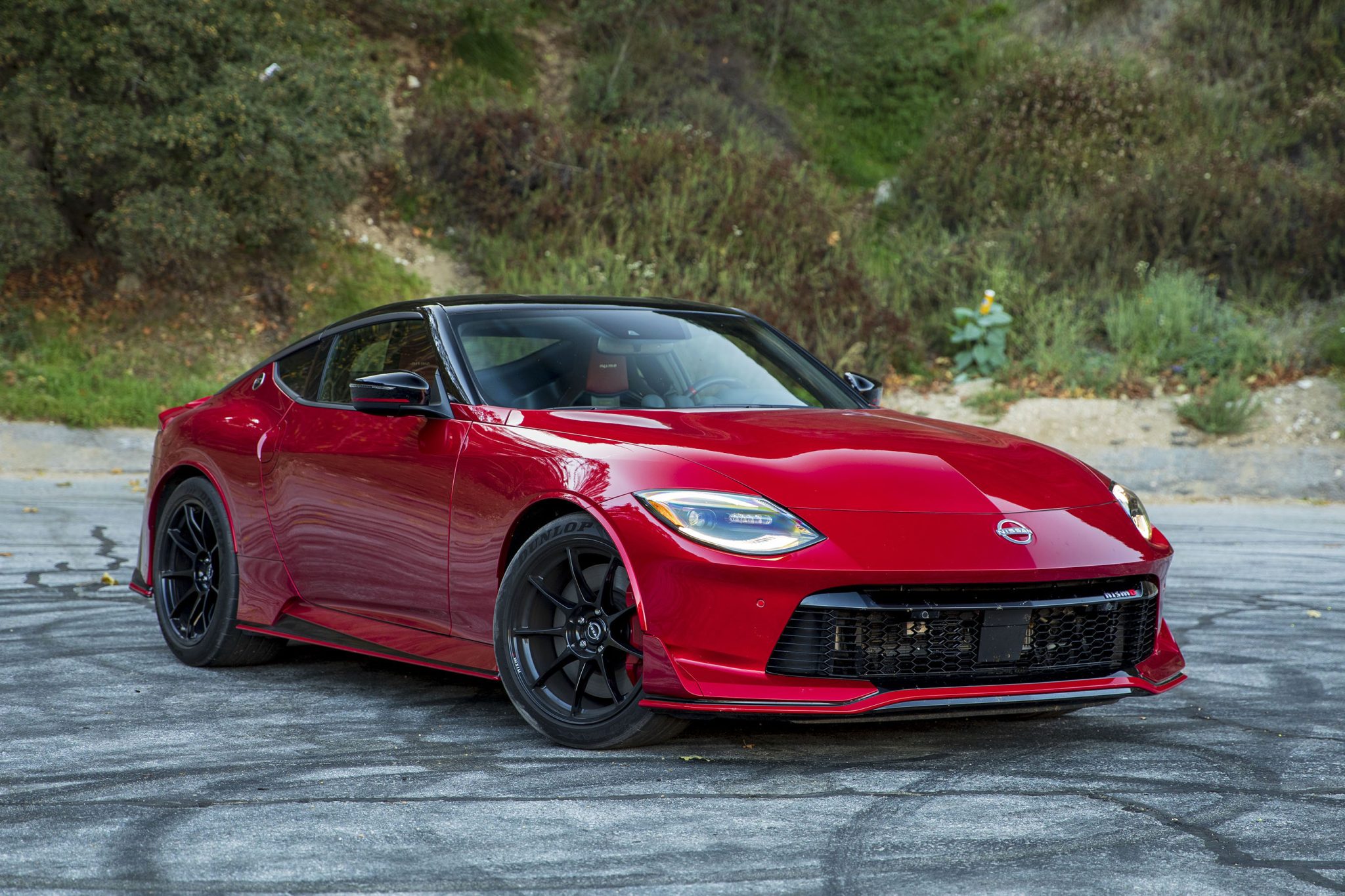A red Nissan Z is standing on the road with rubber marks