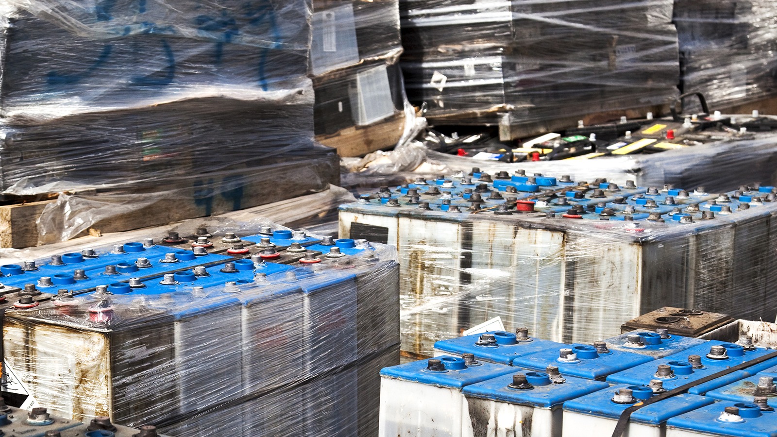 Pallets stacked with used industrial lead-acid batteries 