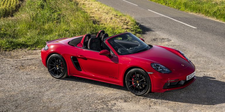 A red Porsche 718 Boxter standing on the side of a highway