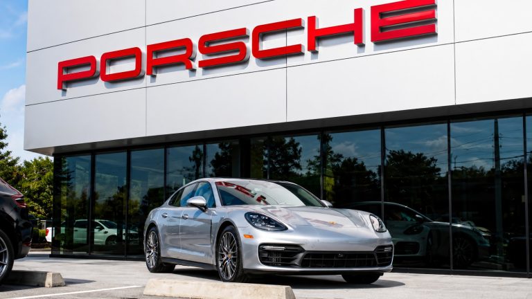 Porsche Panamera parked outside a modern Porsche dealership showroom