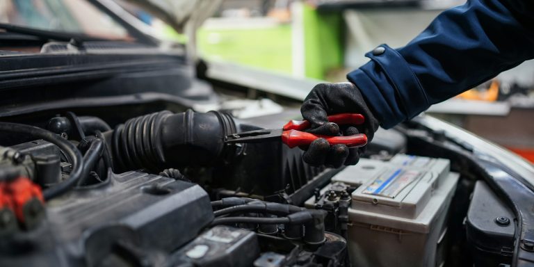 A car mechanic is trying to repair the car engine