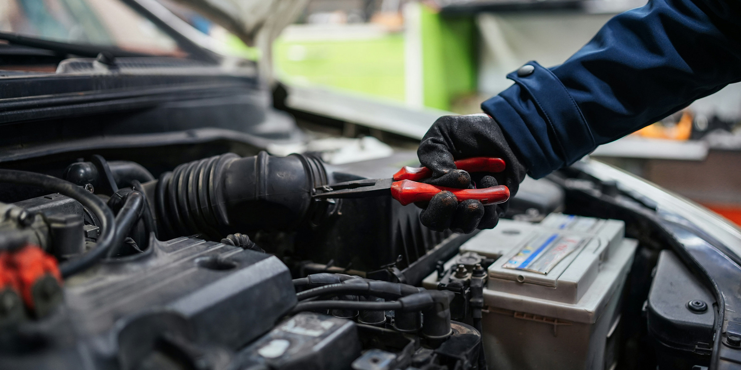 A car mechanic is trying to repair the car engine