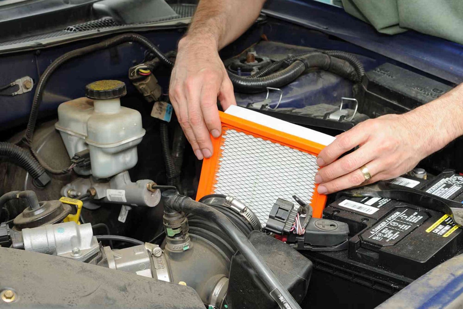 Removing an old engine air filter from a car's engine bay