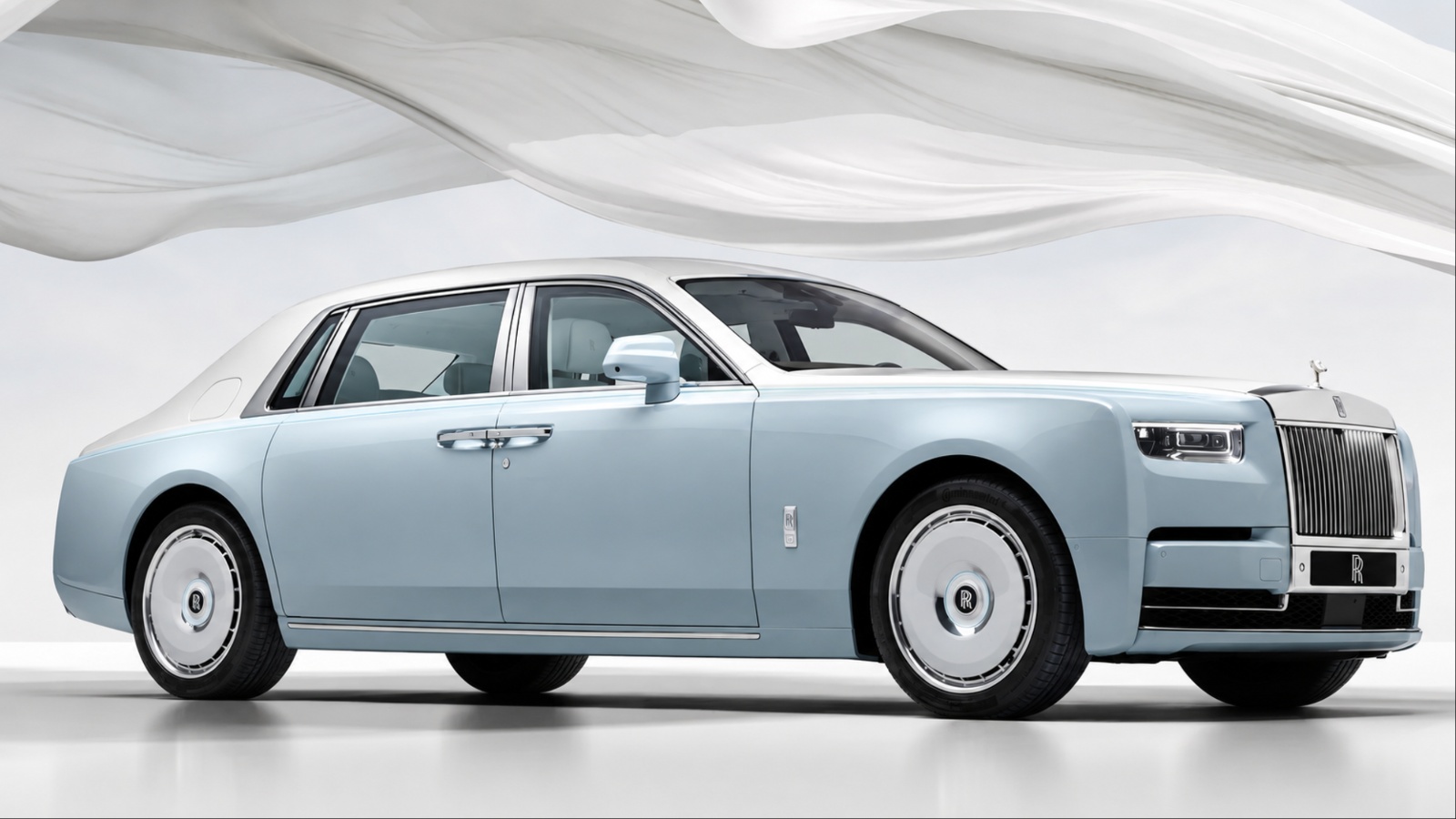 A silver Rolls-Royce is standing in a big closed room